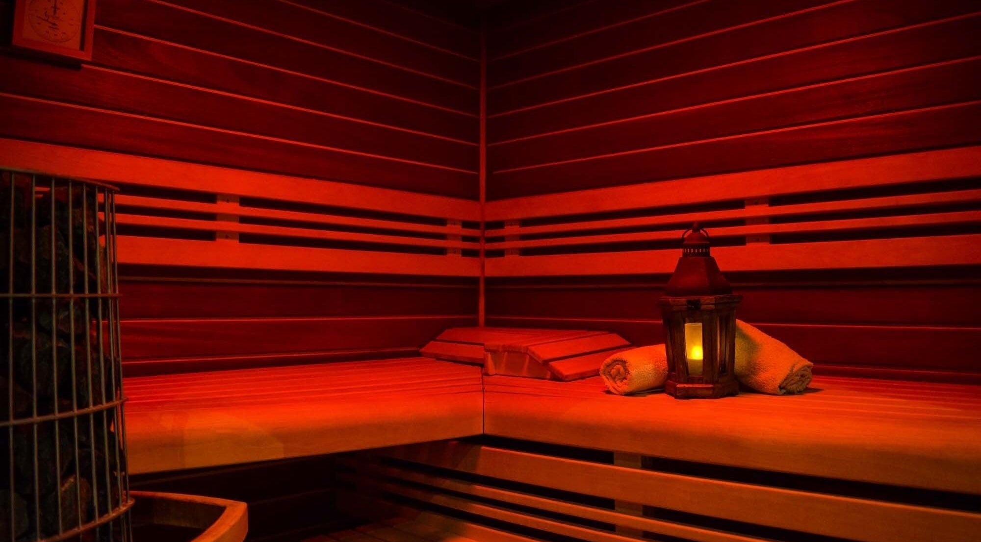 Sauna chaleureux de Spa Eman&sens à Dijon, Bourgogne-franche-comté, FR, avec lumière douce et serviettes.