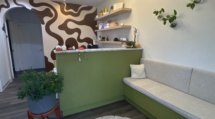Stylish reception at Bold Beauty Esthetics, Oklahoma City, featuring green decor and modern seating.