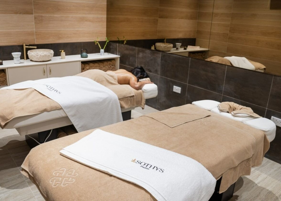 Massage room at E1 Spa and Wellness, Gibraltar, GI, featuring massage tables with soft towels and serene decor.