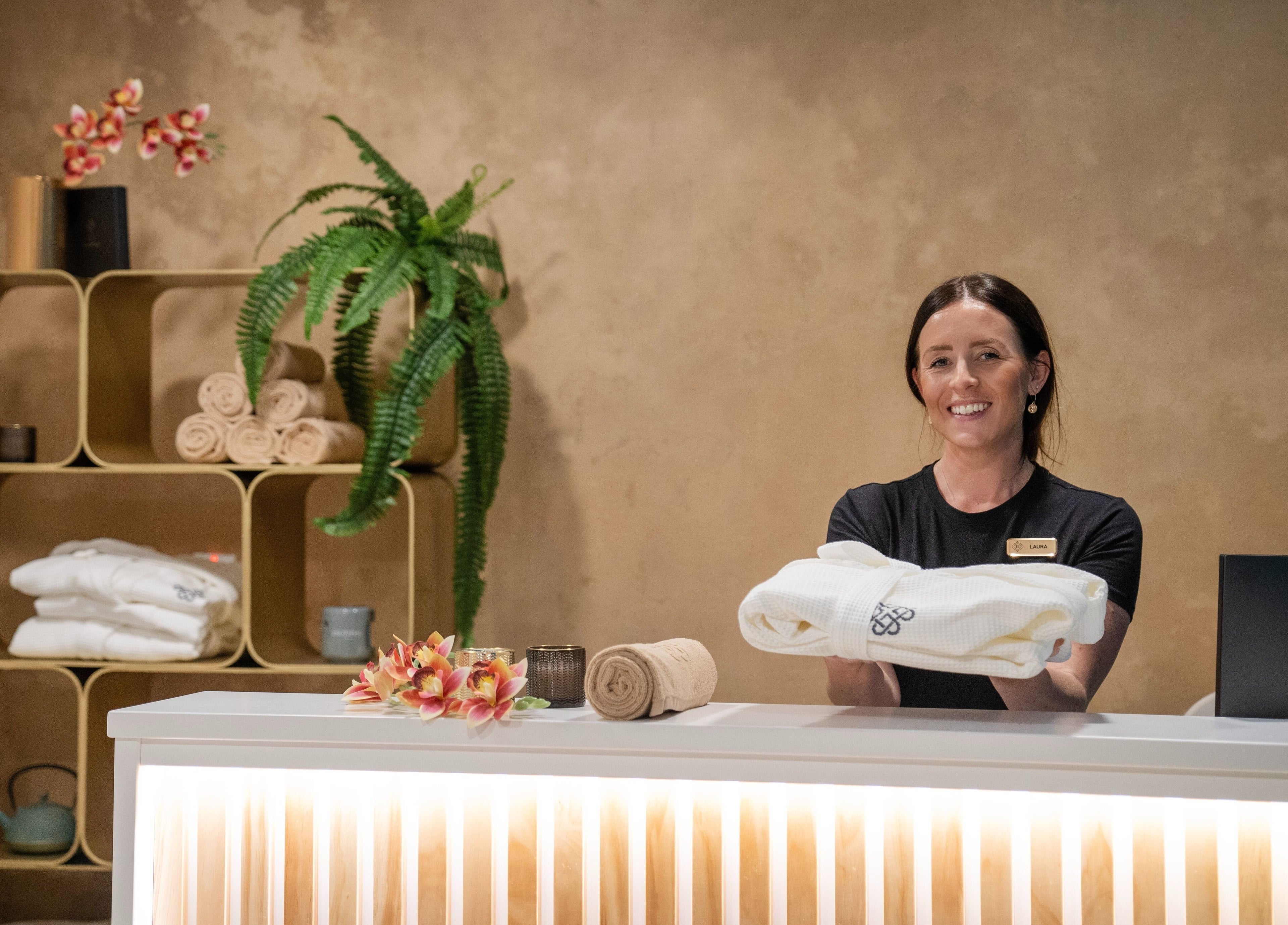 Smiling staff at E1 Spa and Wellness reception, Gibraltar, GI, offering premium service.