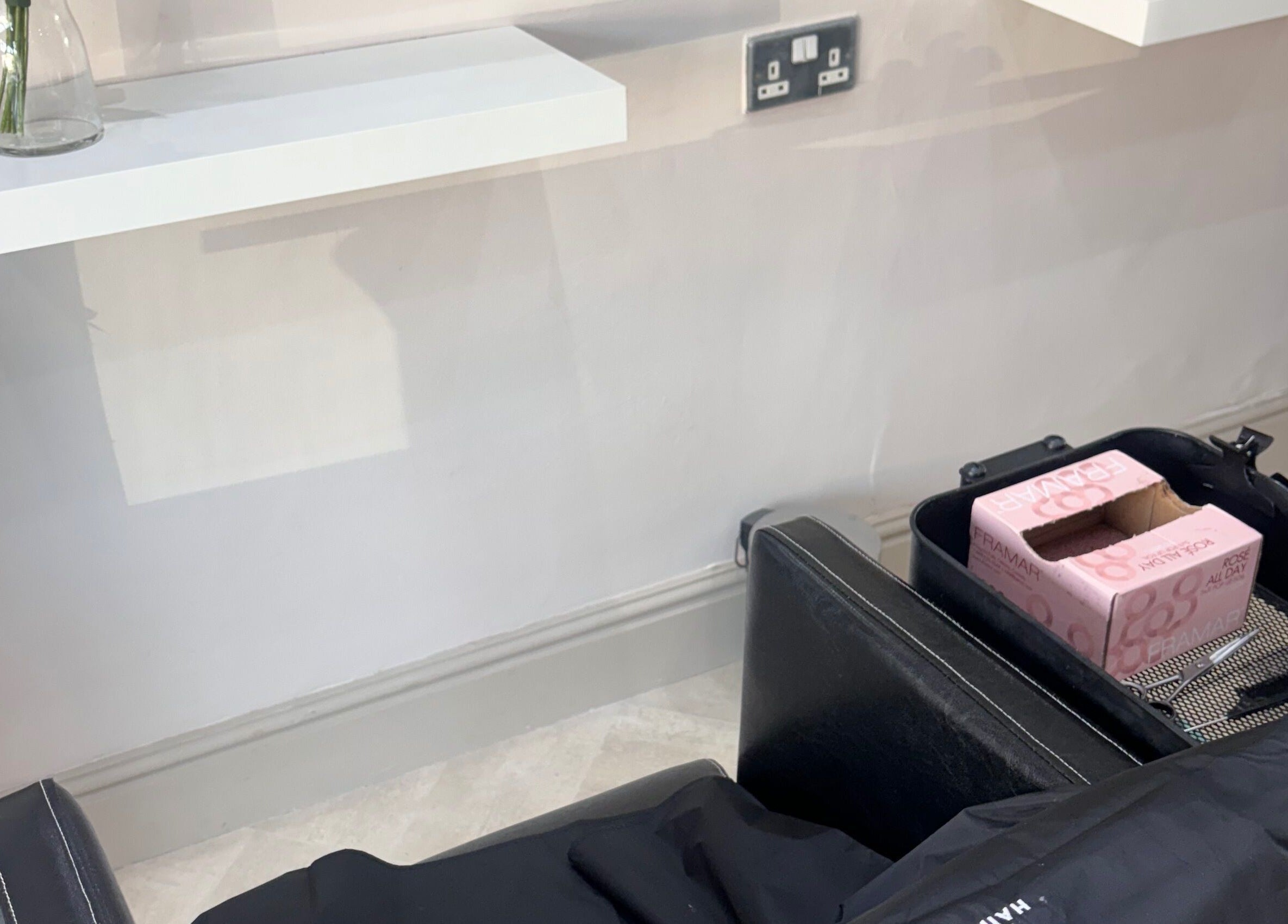 Salon station at Cc Styled It, Birmingham, England, GB with a sleek black chair and shelf.