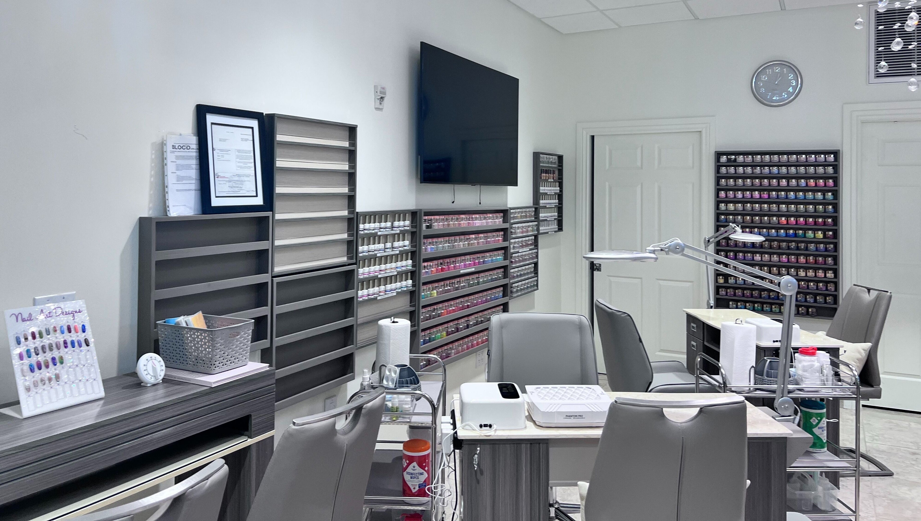 Interior of Tat's Nails Central Phoenix in Phoenix, Arizona, showcasing modern nail stations and polish displays.