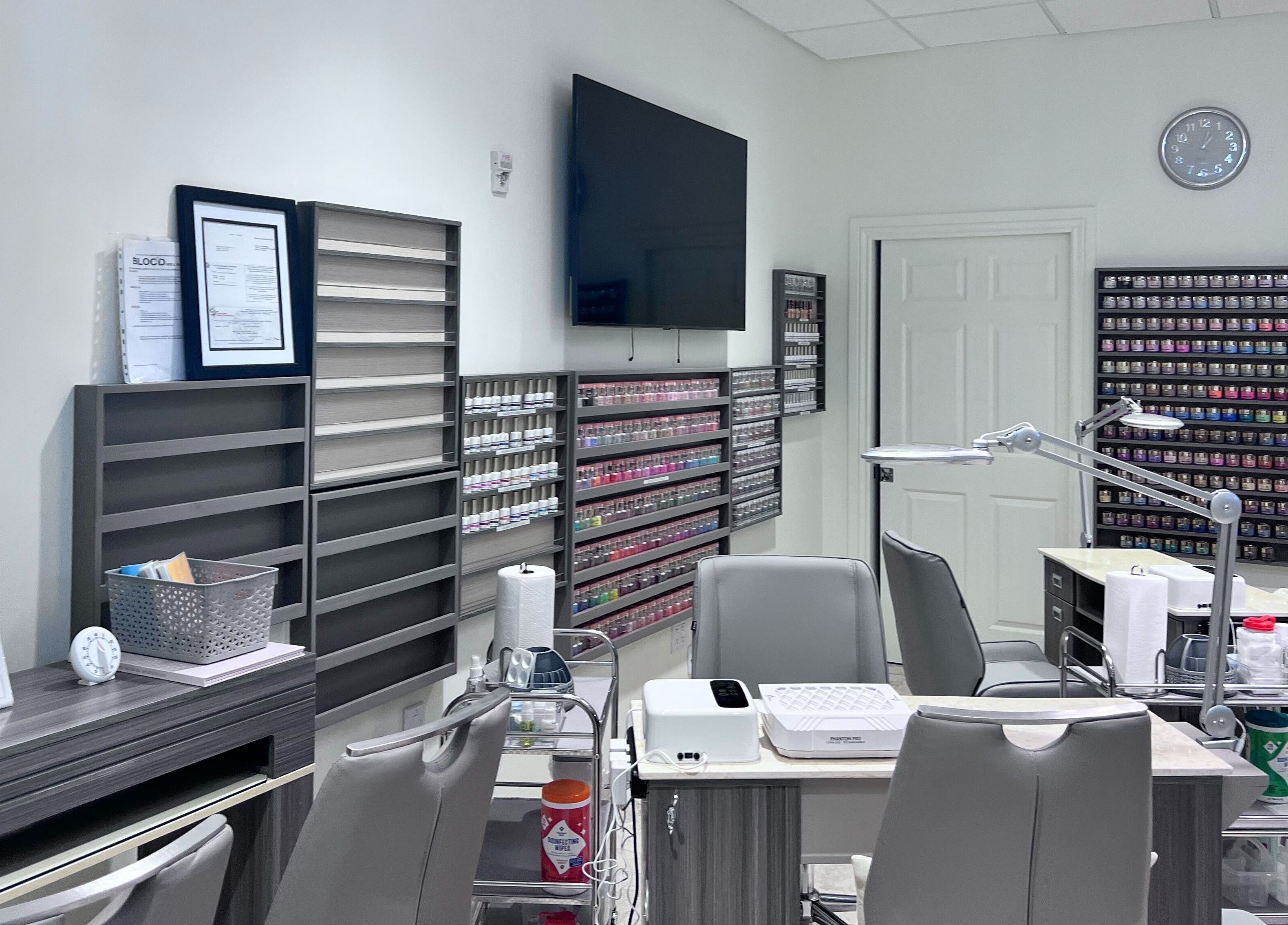 Interior of Tat's Nails Central Phoenix in Phoenix, Arizona, showcasing modern nail stations and polish displays.
