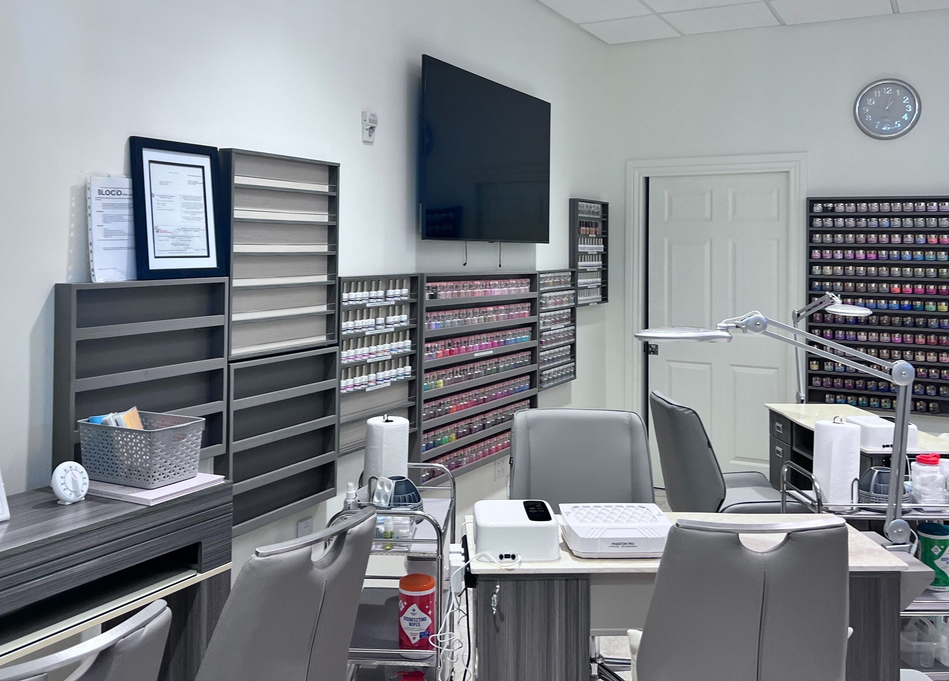 Interior of Tat's Nails Central Phoenix in Phoenix, Arizona, showcasing modern nail stations and polish displays.