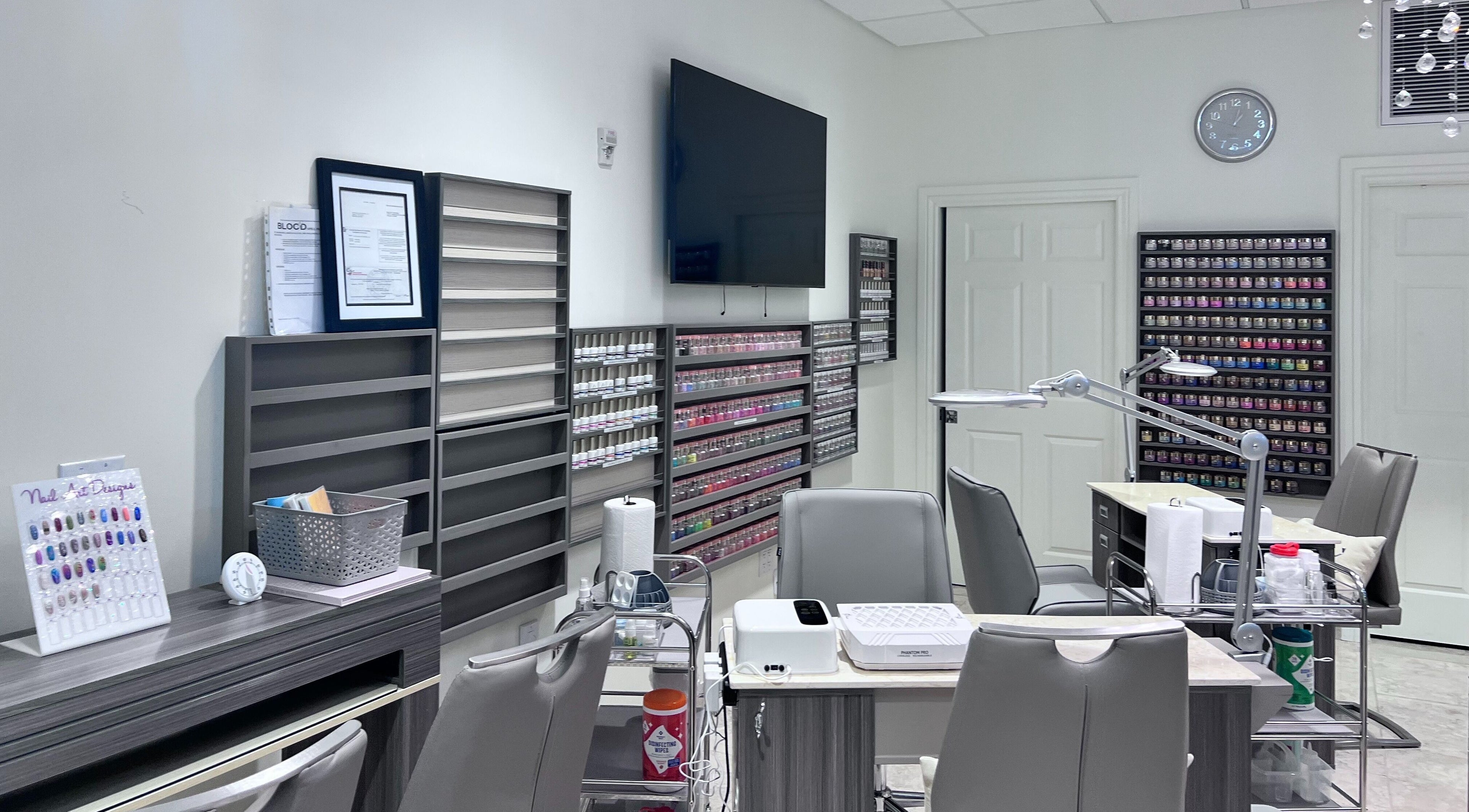 Interior of Tat's Nails Central Phoenix in Phoenix, Arizona, showcasing modern nail stations and polish displays.