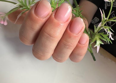 Elegant pink nails holding flowers at Tat's Nails Scottsdale, Scottsdale, Arizona, US.