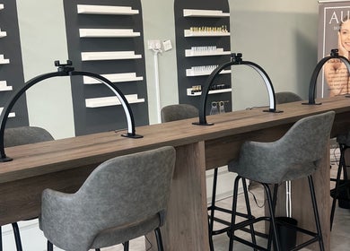 Chic beauty station at Filled Aesthetics, Cannock, England, GB, showcasing sleek chairs and nail polish display.
