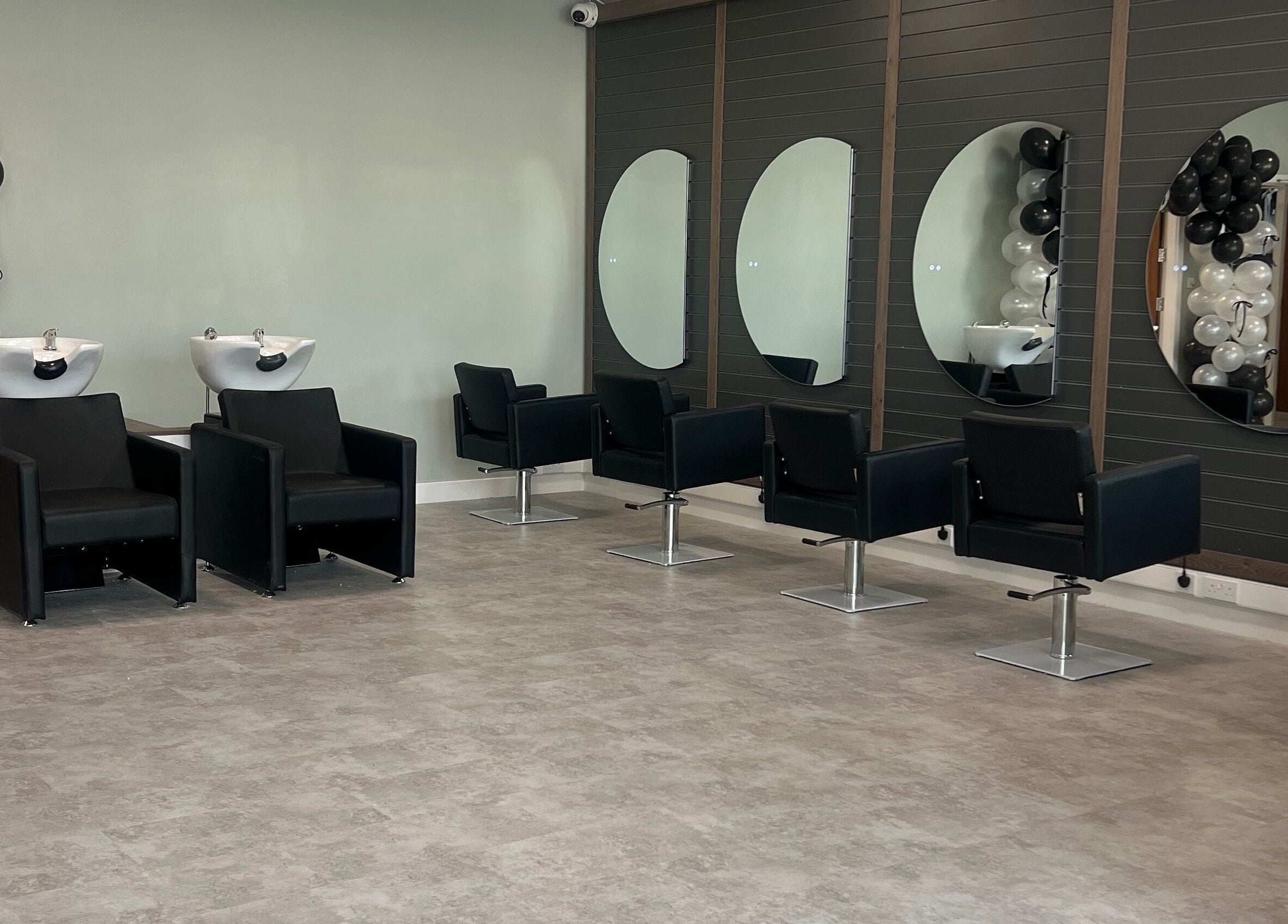 Modern salon interior at Filled Aesthetics, Cannock, England, GB, featuring stylish chairs and mirrors.