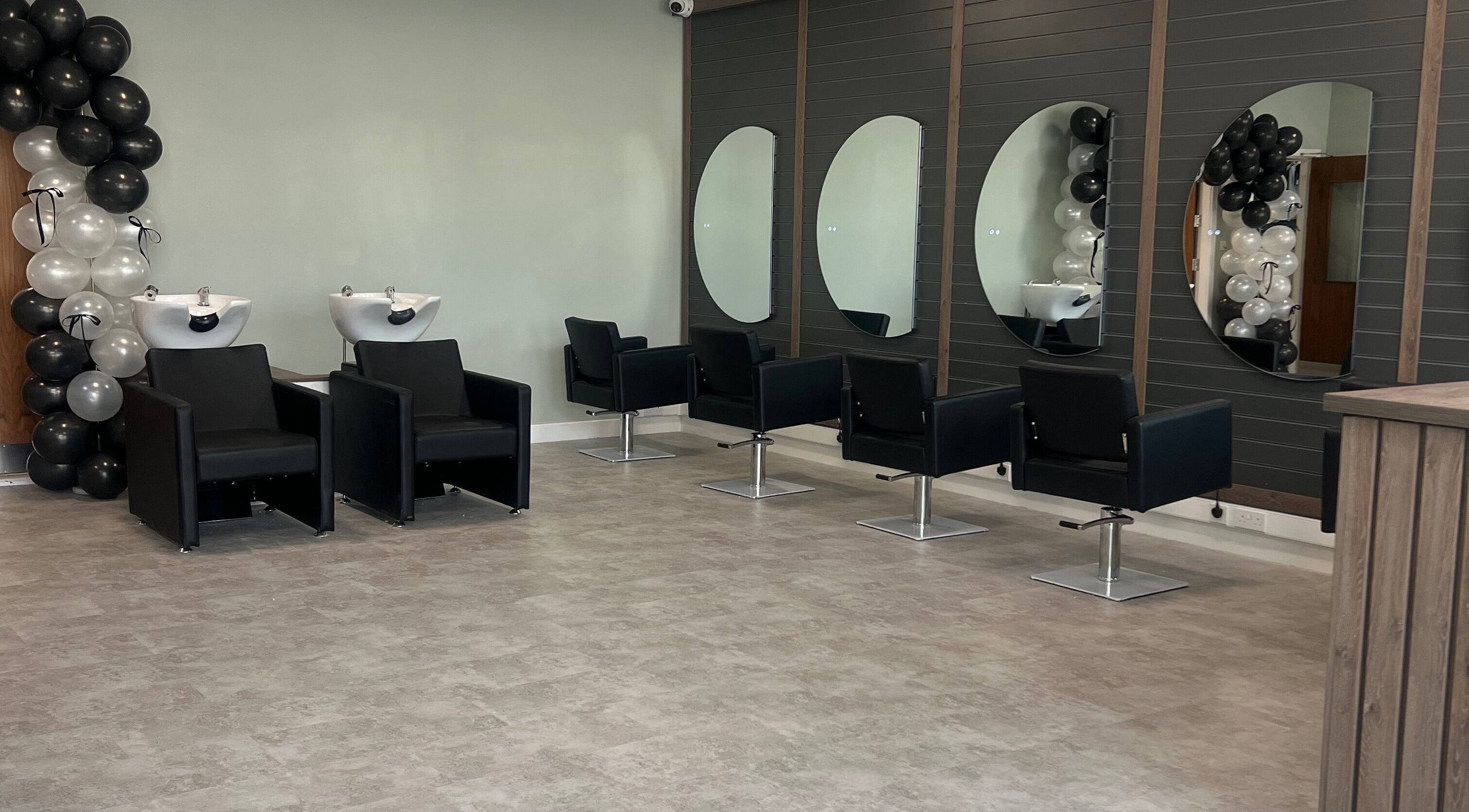 Modern salon interior at Filled Aesthetics, Cannock, England, GB, featuring stylish chairs and mirrors.