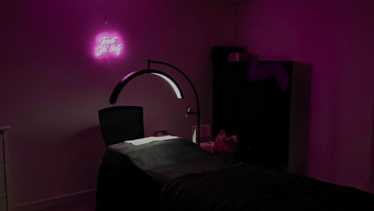 Cozy treatment room at Beauty Arcade, West Leederville, Australia, with ambient pink lighting and modern decor.