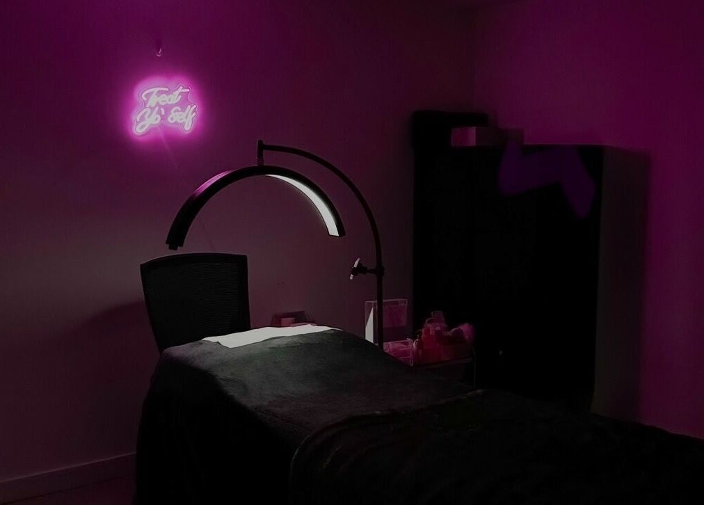 Cozy treatment room at Beauty Arcade, West Leederville, Australia, with ambient pink lighting and modern decor.