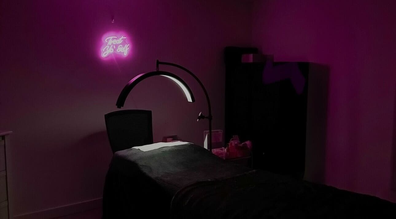 Cozy treatment room at Beauty Arcade, West Leederville, Australia, with ambient pink lighting and modern decor.