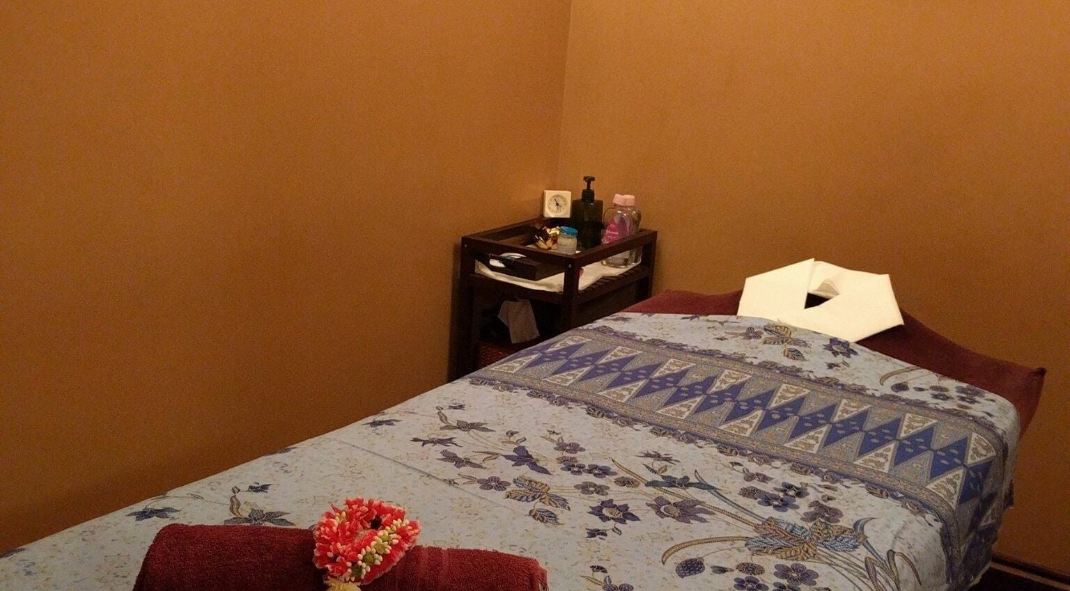 Tranquil massage room at Benjawan Thai Massage and Therapy in London, England, GB, featuring a decorated bed.
