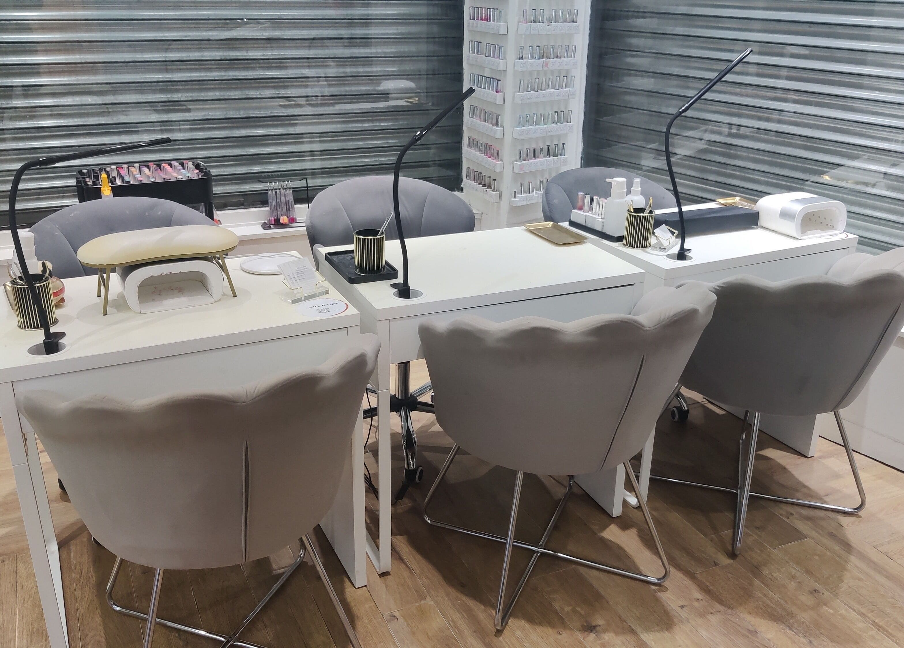 Manicure station at Enhance Hair & Beauty, Clarkston, Scotland, GB, featuring modern chairs and nail care tools.