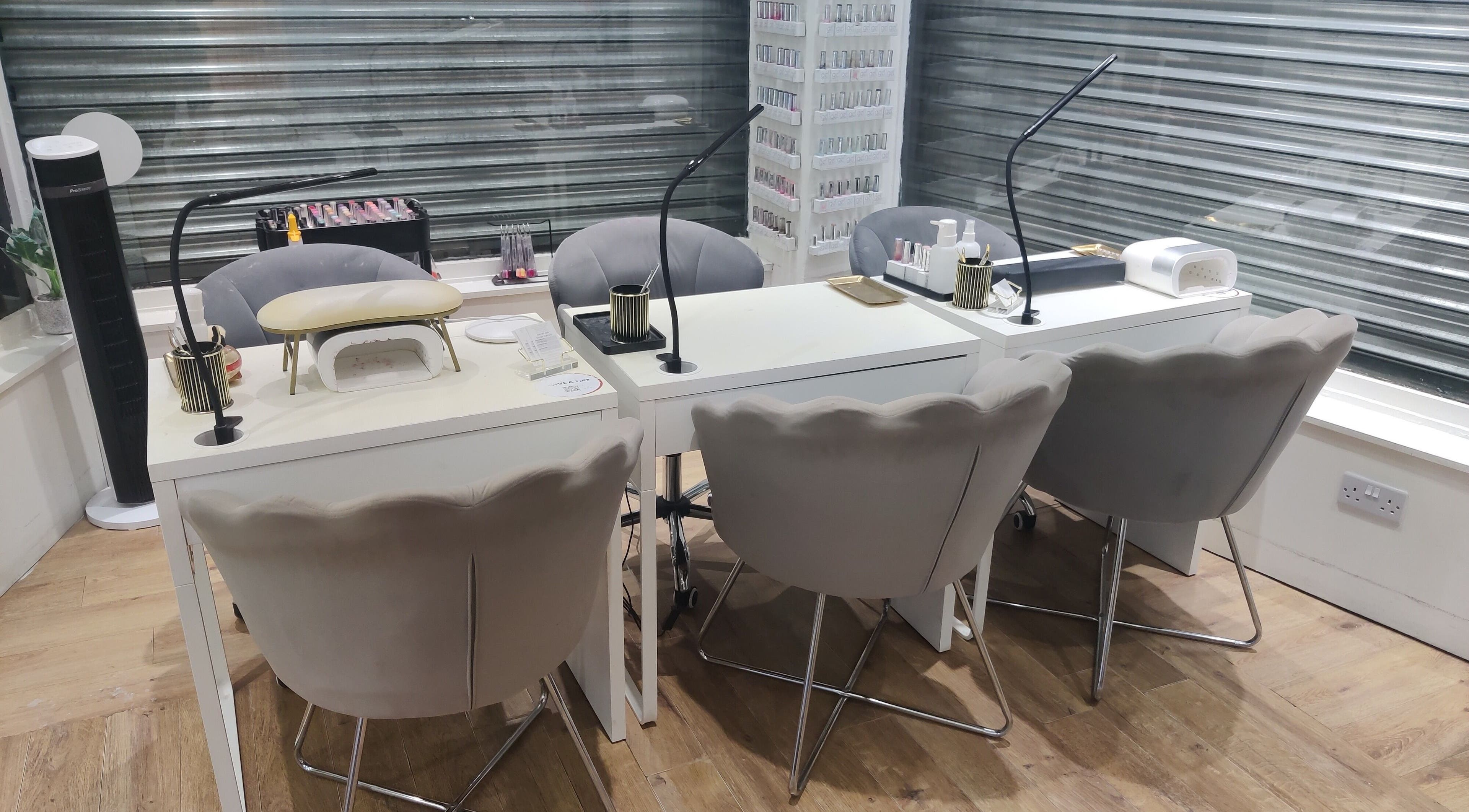 Manicure station at Enhance Hair & Beauty, Clarkston, Scotland, GB, featuring modern chairs and nail care tools.