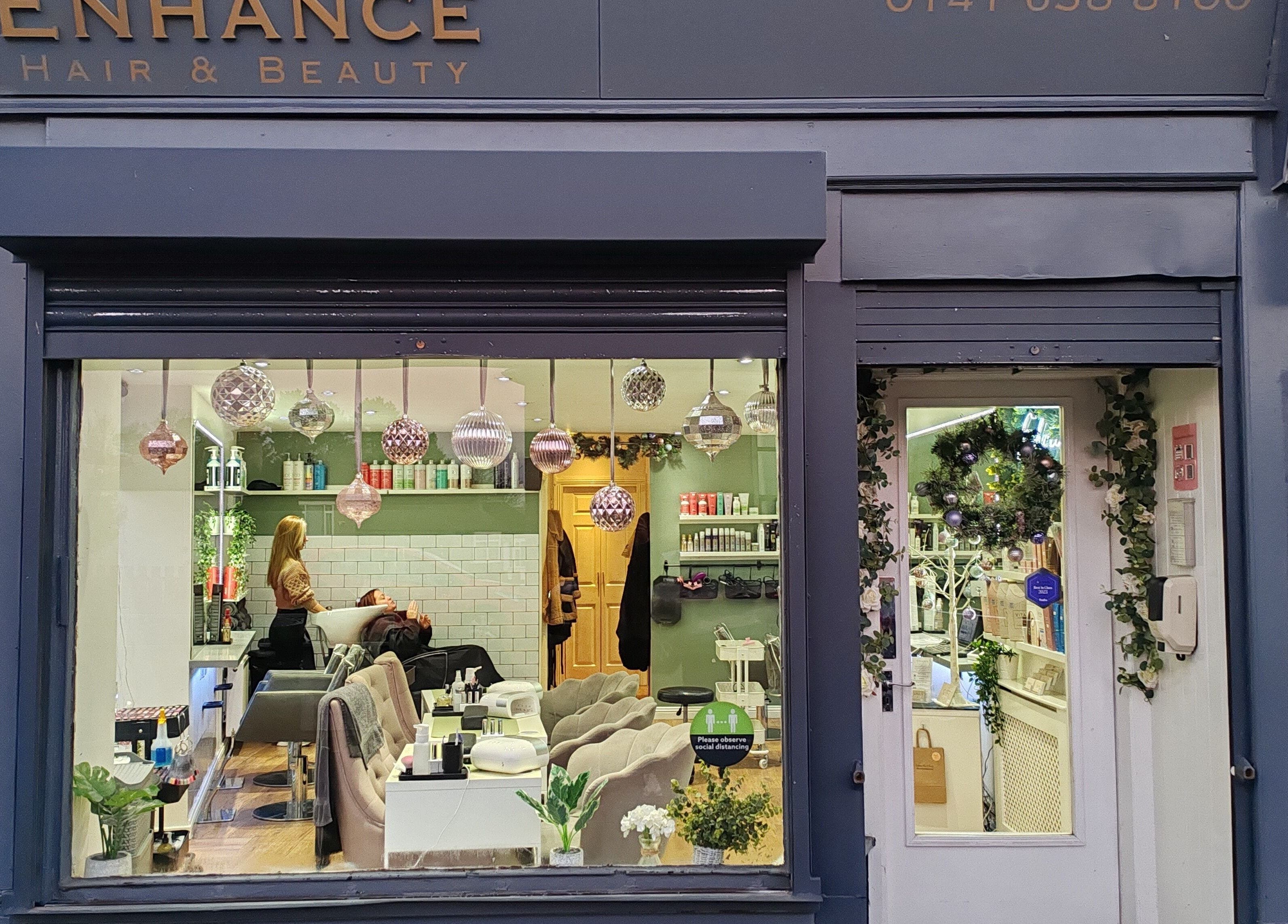 Enhance Hair & Beauty salon storefront in Clarkston, Scotland, GB, displaying festive interior decor.