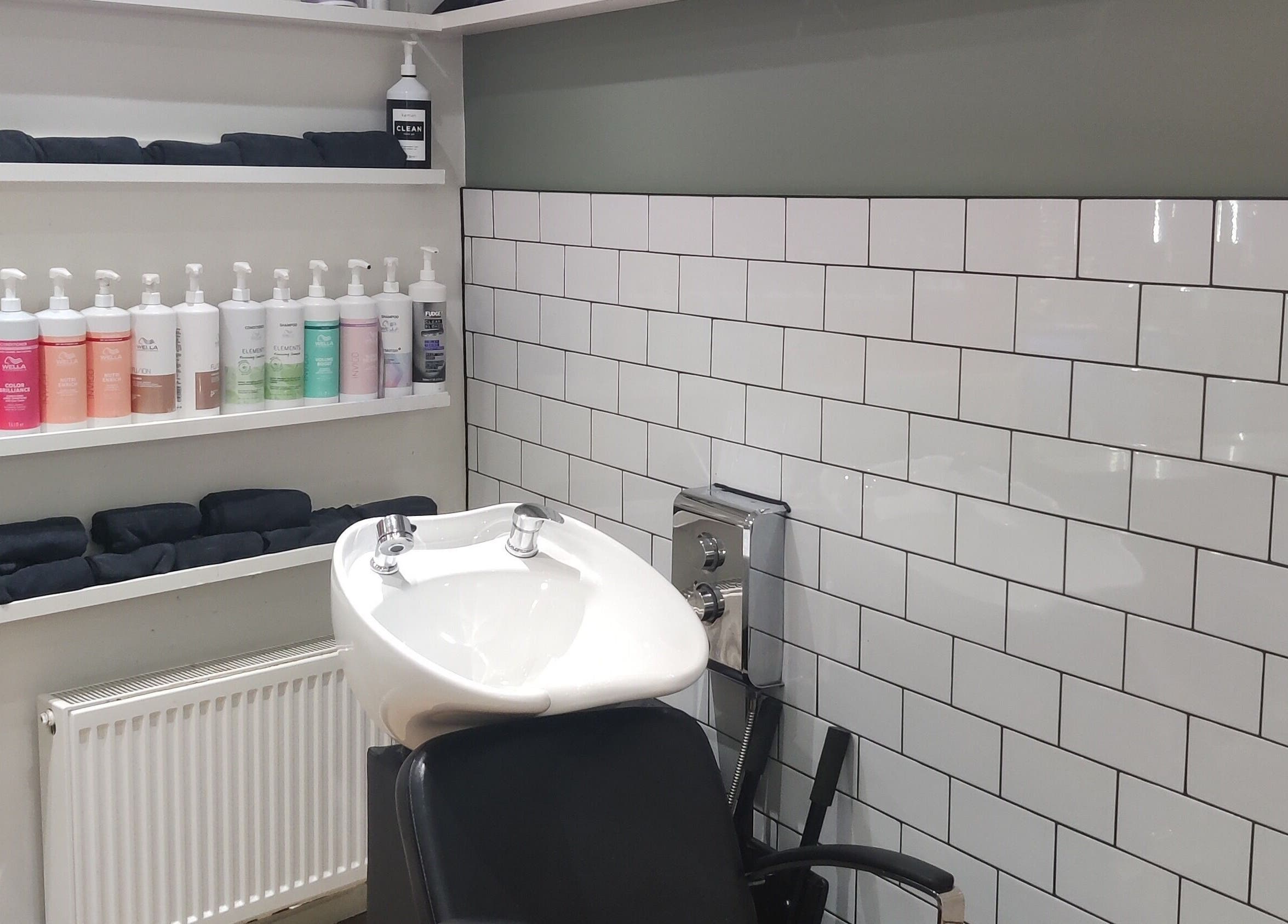 Modern wash station at Enhance Hair & Beauty, Clarkston, Scotland, GB featuring sleek design and variety of products.