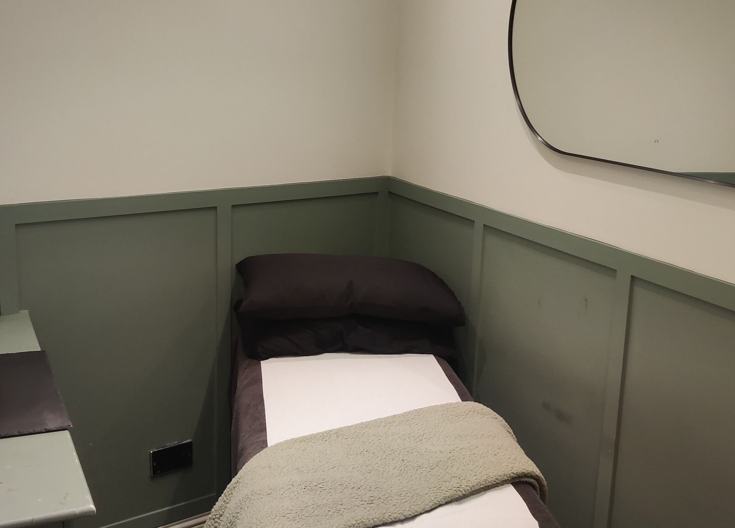 Relaxing treatment room at Enhance Hair & Beauty, Clarkston, Scotland, GB with comfy bed and stylish decor.