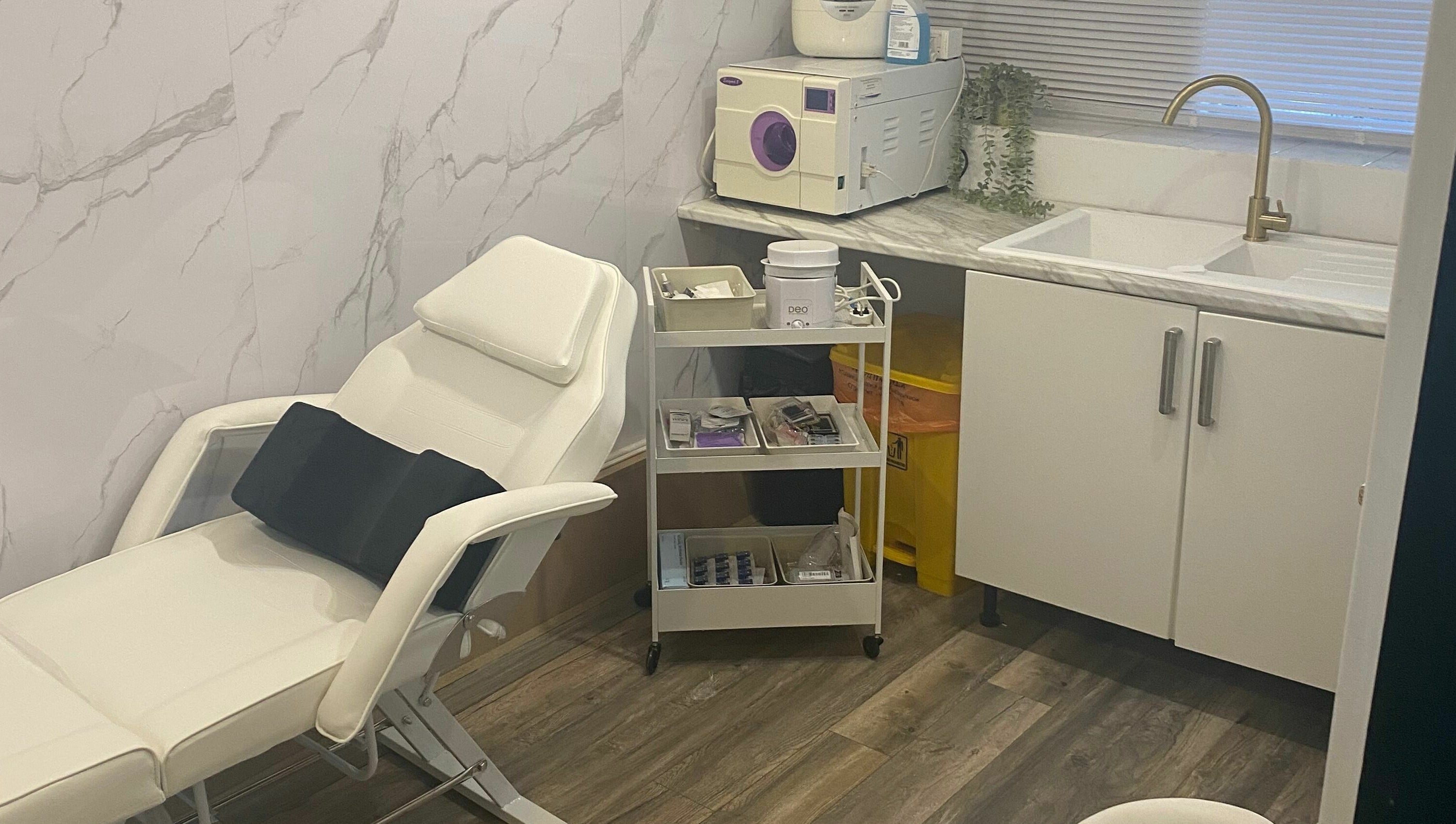 Modern spa room at Dy9 Design, Stourbridge, England, GB with white recliner, marble counter, and treatment tools.