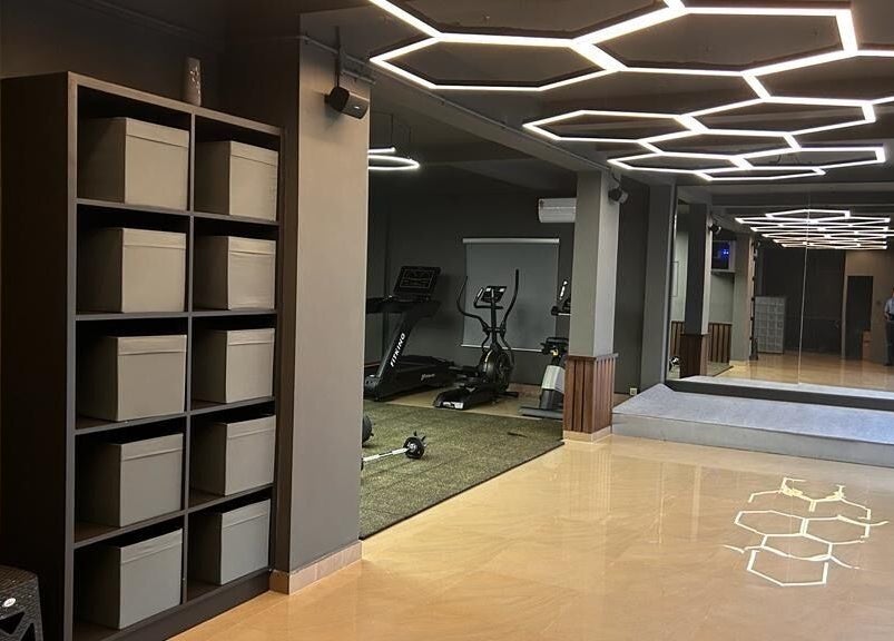 Modern gym at One Touch Fit & Glam, Thiruvananthapuram, Kerala, IN with hexagon ceiling lights and fitness equipment.