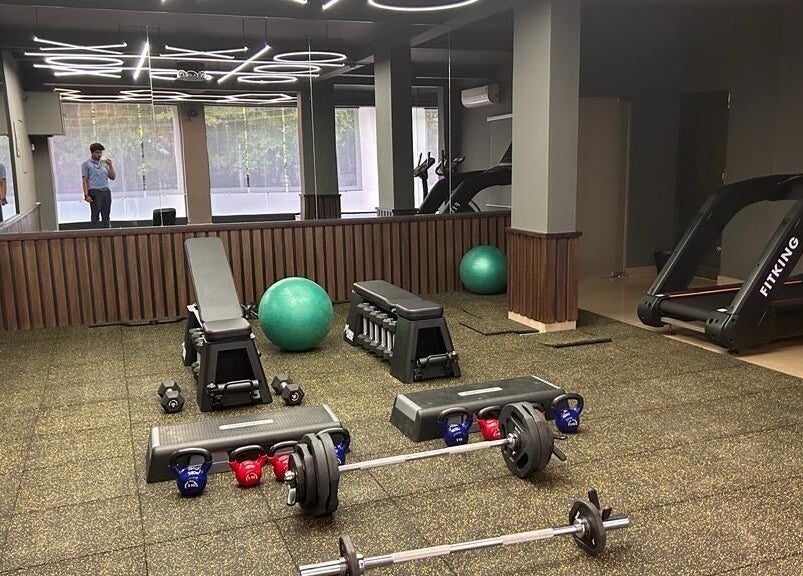 Modern gym interior at One Touch Fit & Glam, Thiruvananthapuram, Kerala featuring equipment for diverse workouts.