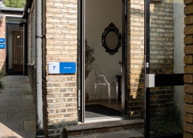 Entrance to Ana Clara Barreto Beauty, London, England, GB, showcasing brick walls and a welcoming pathway.