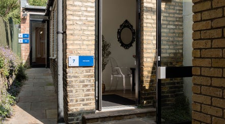 Entrance to Ana Clara Barreto Beauty, London, England, GB, showcasing brick walls and a welcoming pathway.