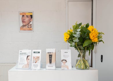Reception desk with vibrant sunflowers at Ana Clara Barreto Beauty, London, England, GB.