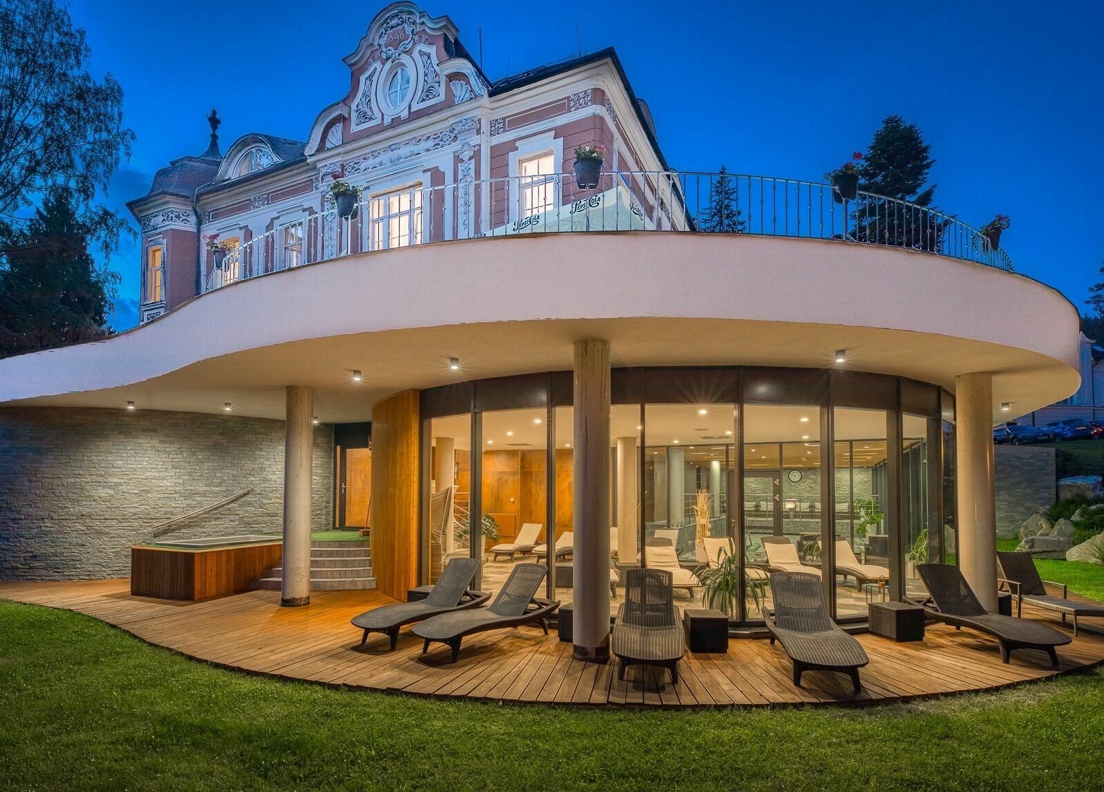 Wellness and Spa Hotel Villa Regenhart v Jeseník, Olomoucký kraj, CZ při večerním osvětlení s relaxačními lehátky.