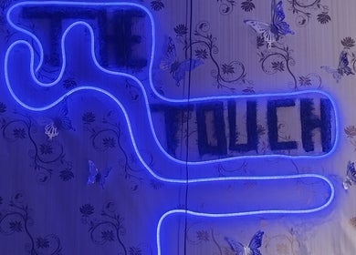 Glowing neon sign of TheTouch by leoRock on a wallpaper with butterflies in Johannesburg, Gauteng, ZA.