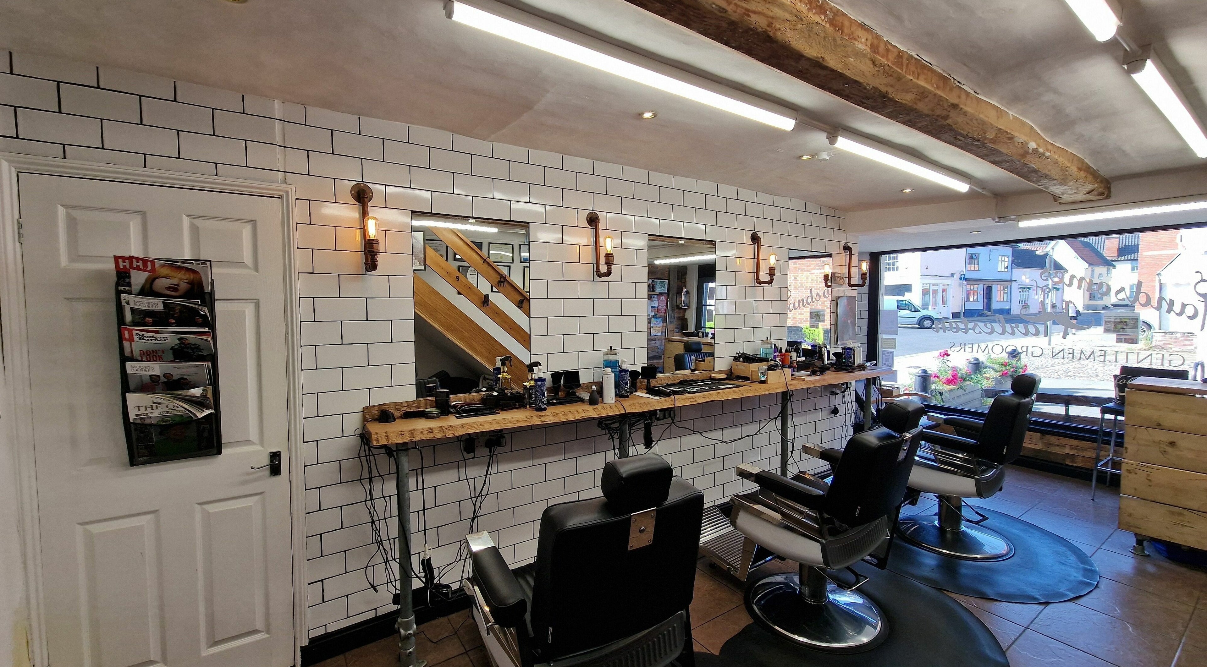 Elegant interior of Handsomes of Harleston barber shop in Harleston, England, GB with stylish barber chairs.