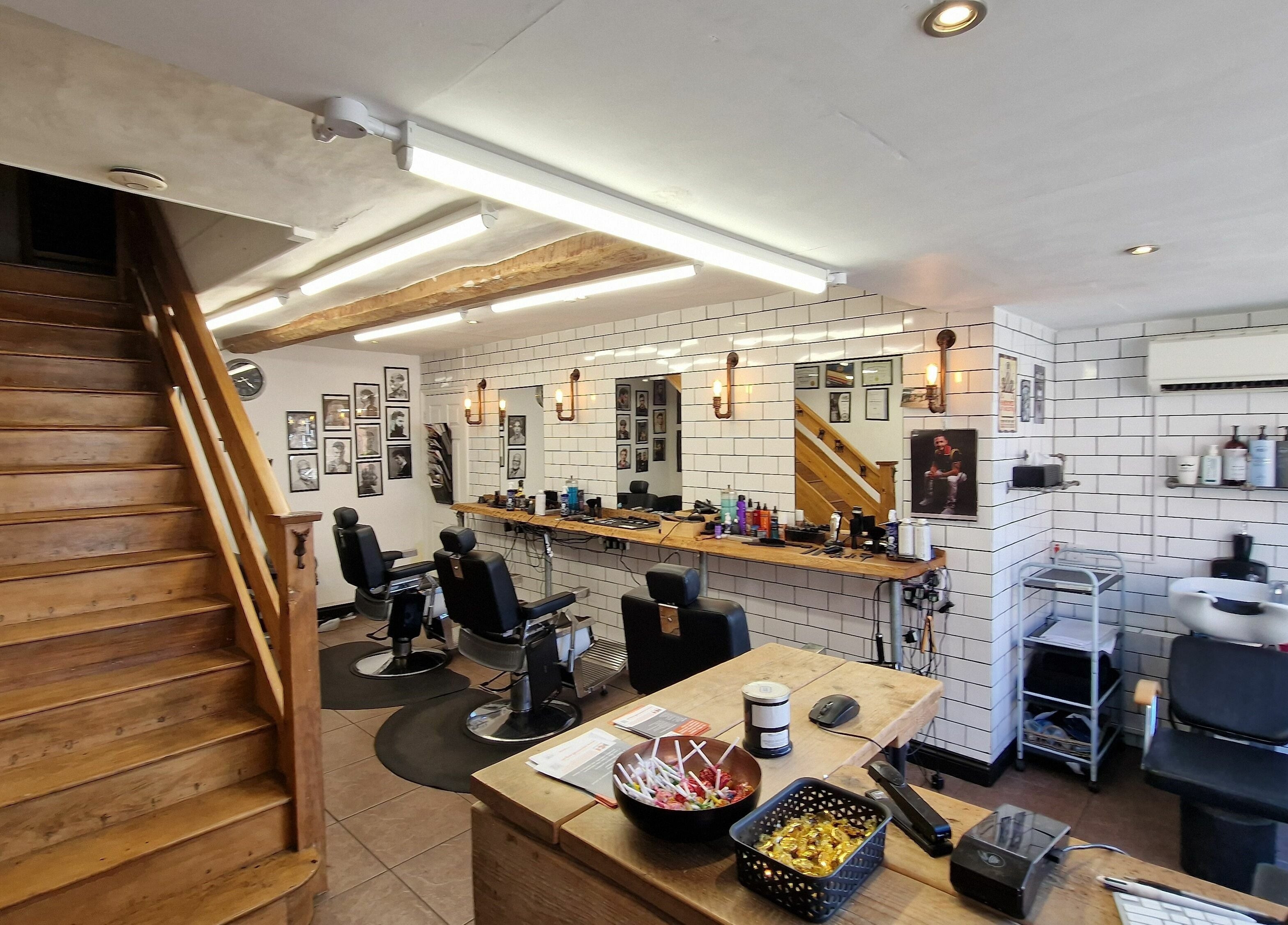 Sleek barber interior at Handsomes of Harleston in Harleston, England, GB with stylish chairs and decor.