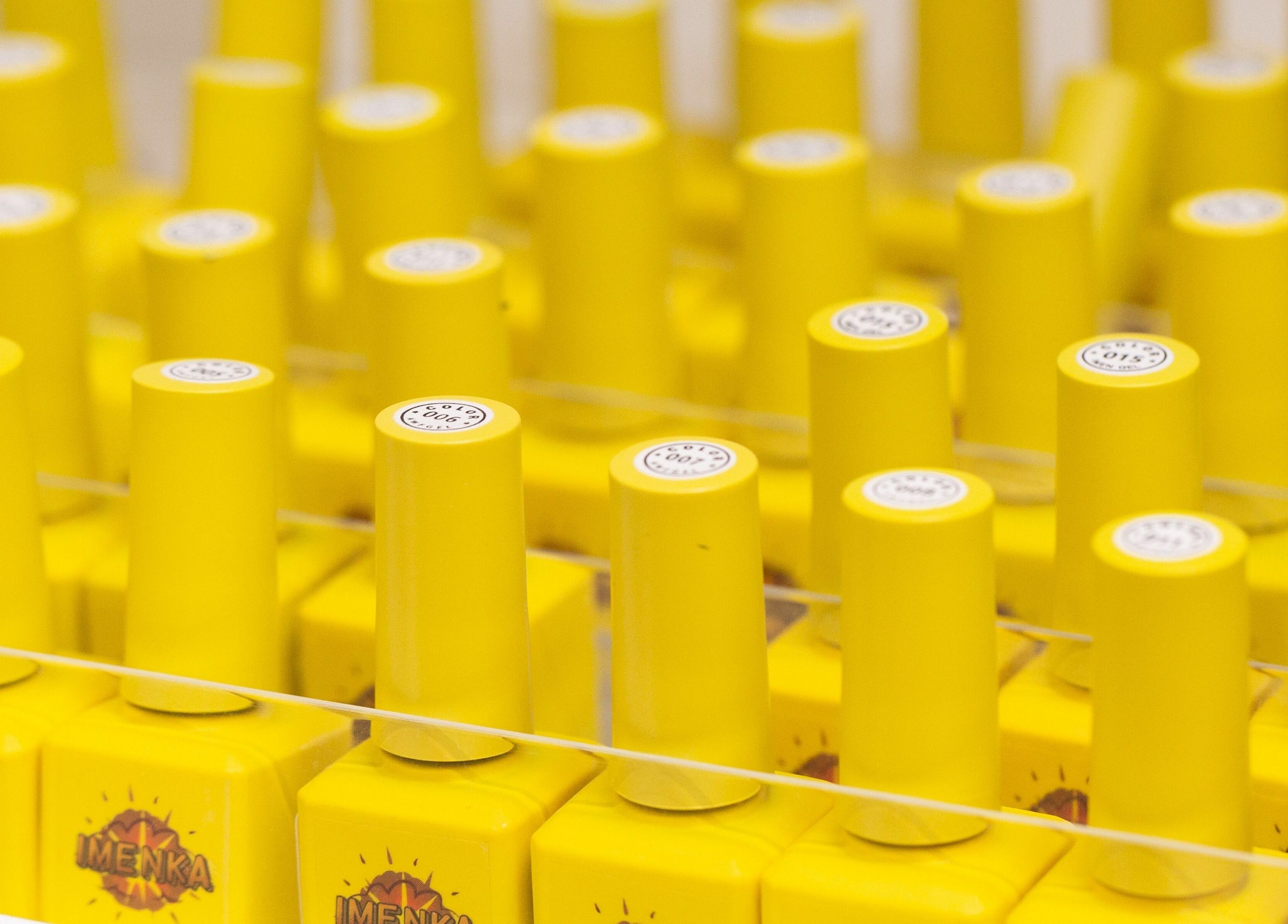Bright yellow nail polish caps at Zaranailsnyc, New York, United States, US.