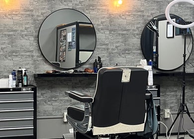 Modern interior of Dapper Hub Barbershop- PANMURE in Auckland, Auckland, NZ with sleek chairs and mirrors.