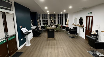 Interior of Evolve Salon, Clacton-on-sea, England, GB, showcasing stylish chairs and large windows.