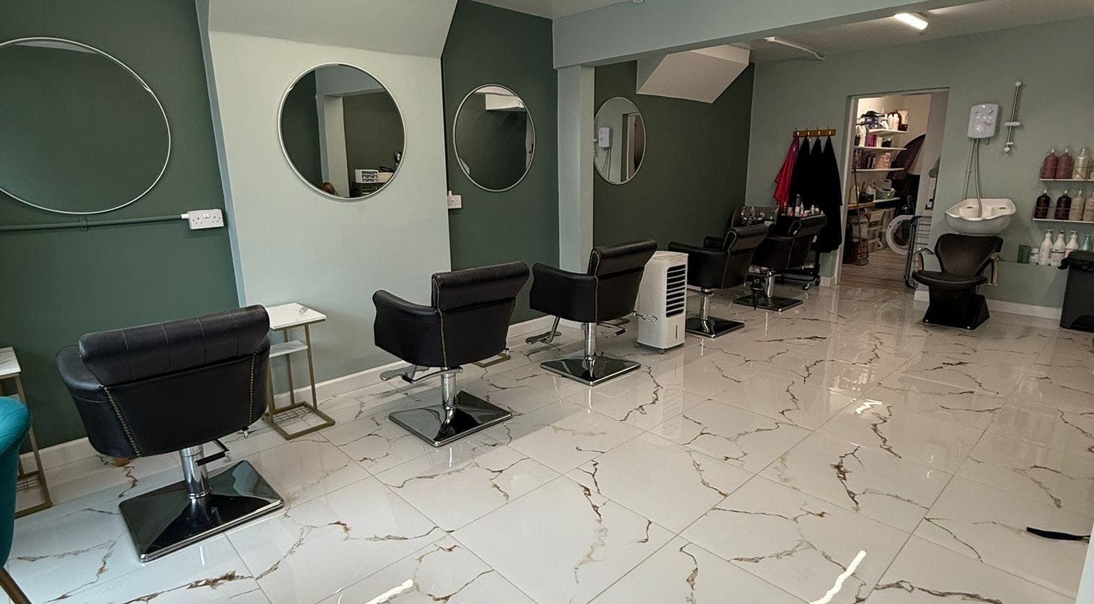 Stylish interior of Evolve Salon in Clacton-on-sea, England, GB featuring elegant salon chairs.