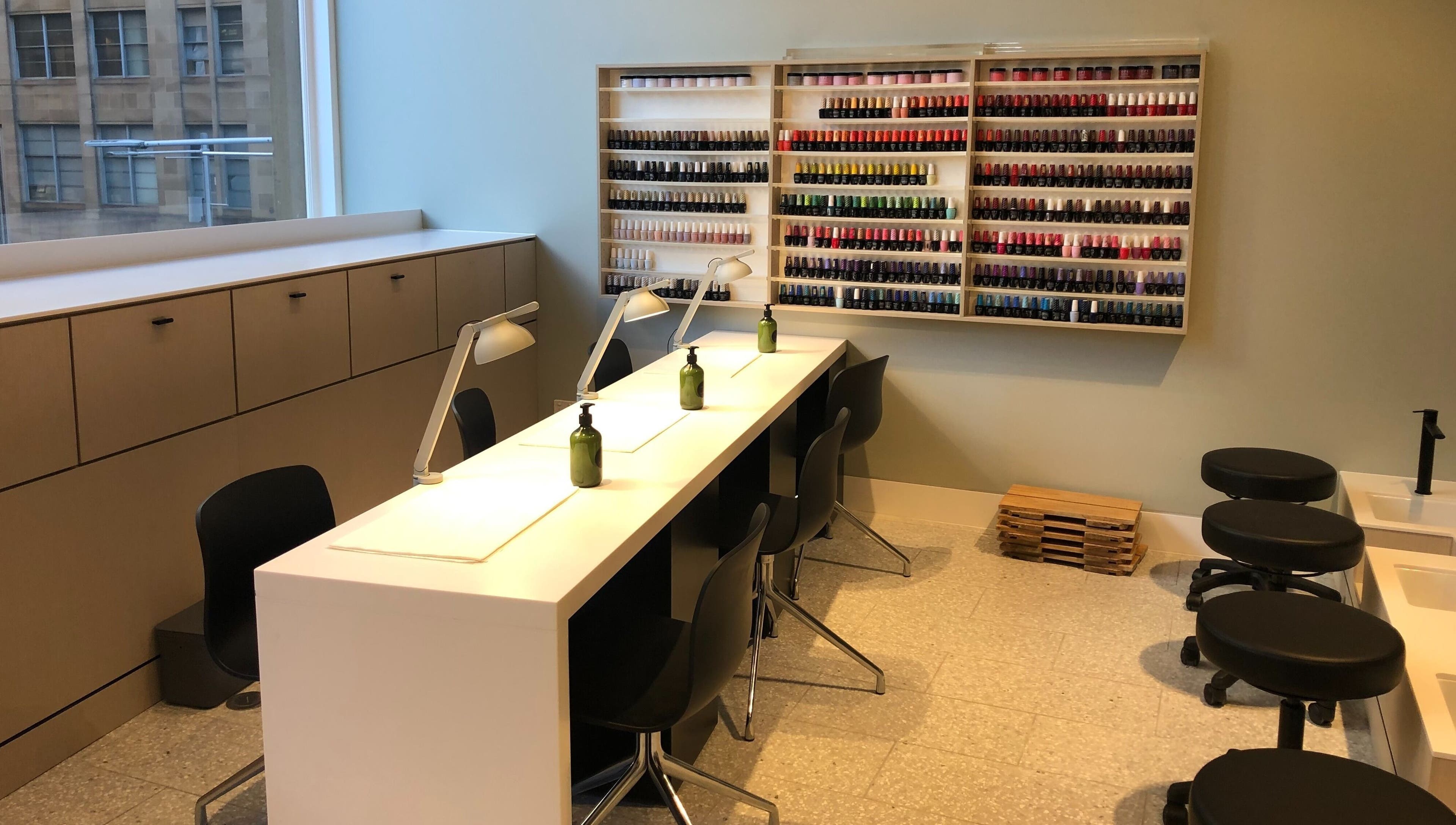 Manicure area at Beauty Bar at David Jones, Sydney, New South Wales, AU with stylish seating and colorful polish display.
