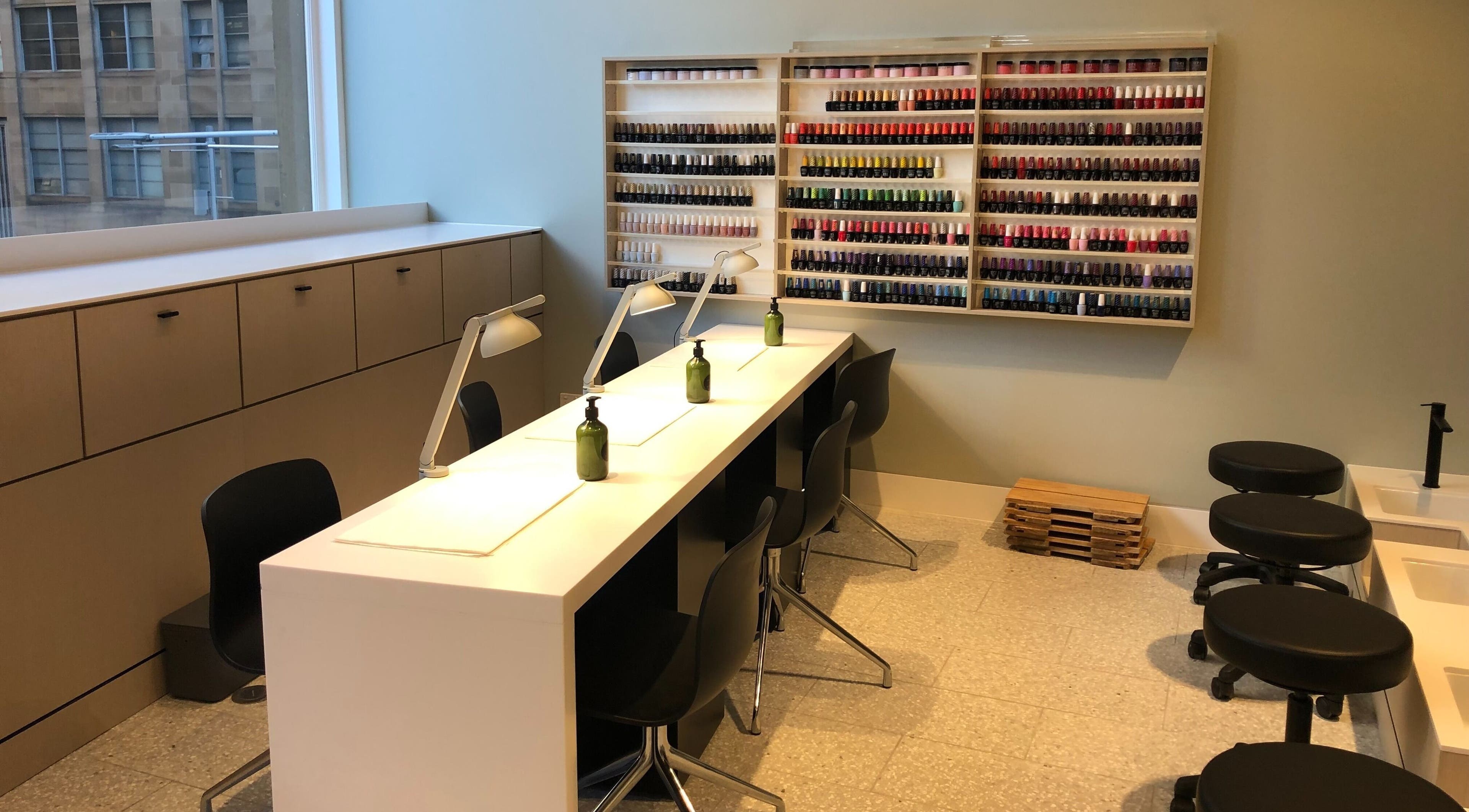 Manicure area at Beauty Bar at David Jones, Sydney, New South Wales, AU with stylish seating and colorful polish display.