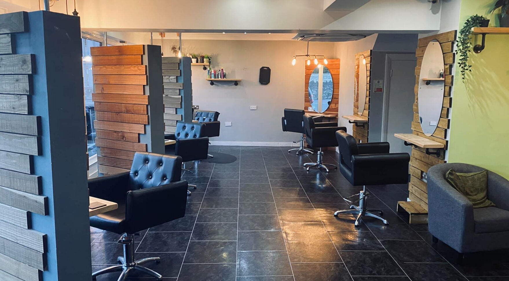 Modern salon chairs and mirrors at Hair At Rehab Limited in Kingsteignton, England, GB.
