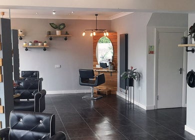 Modern salon interior at Hair At Rehab Limited, Kingsteignton, with stylish seating and decor elements.