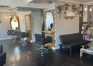 Modern salon interior at Hair At Rehab Limited, Kingsteignton, England, featuring stylish seating and decor.