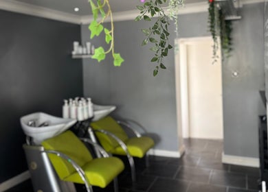 Chic interior of Hair At Rehab Limited in Kingsteignton, England featuring vibrant salon chairs and decor.
