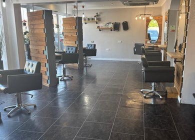 Modern salon interior at Hair At Rehab Limited, Kingsteignton, England, GB with stylish chairs and mirrors.