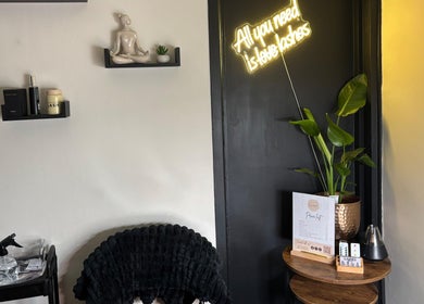 Relaxing corner at Hair At Rehab Limited, Kingsteignton, England, featuring decor and neon sign.