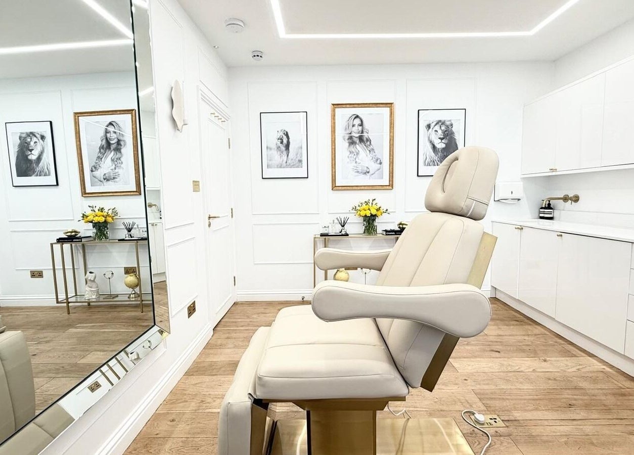 Sleek treatment room at Aesthetic by Maria, London, England, GB with modern decor and a comfortable chair.