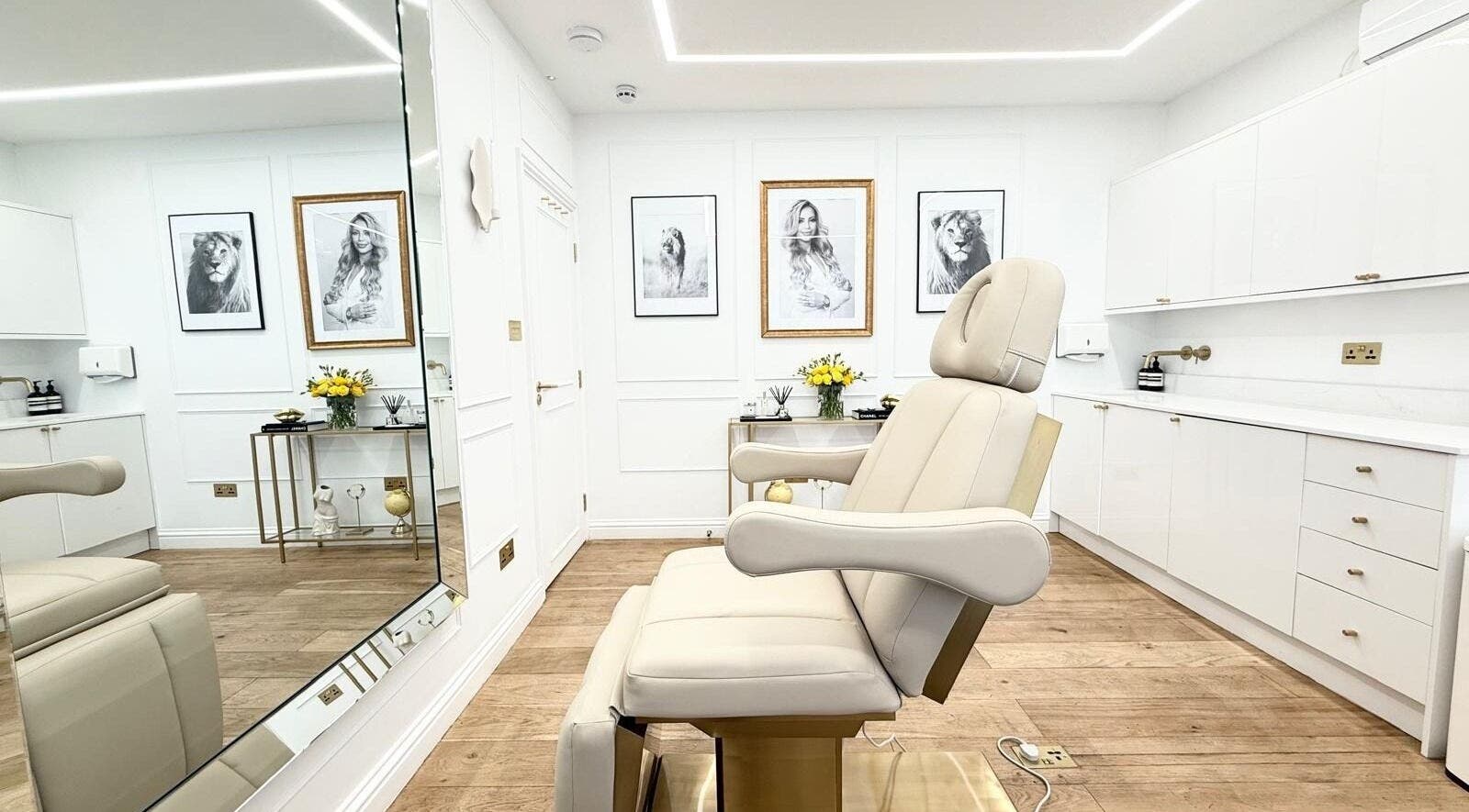 Sleek treatment room at Aesthetic by Maria, London, England, GB with modern decor and a comfortable chair.