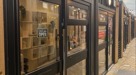 Entrance to Mais Nails in Barry, Wales, GB features a modern glass facade with open sign.
