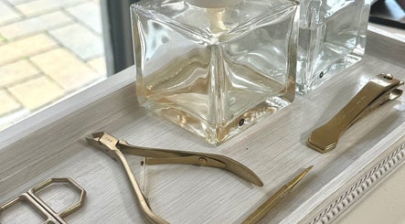 Polished nail tools and glass bottles at Mais Nails, Barry, Wales, GB offering premium manicure services.