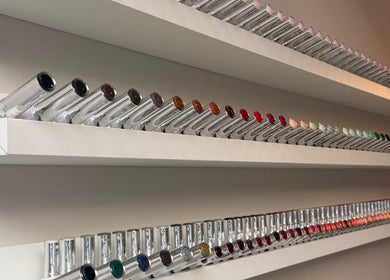 Colorful nail polish selection at Mais Nails, Barry, Wales, GB, displayed on sleek white shelves.