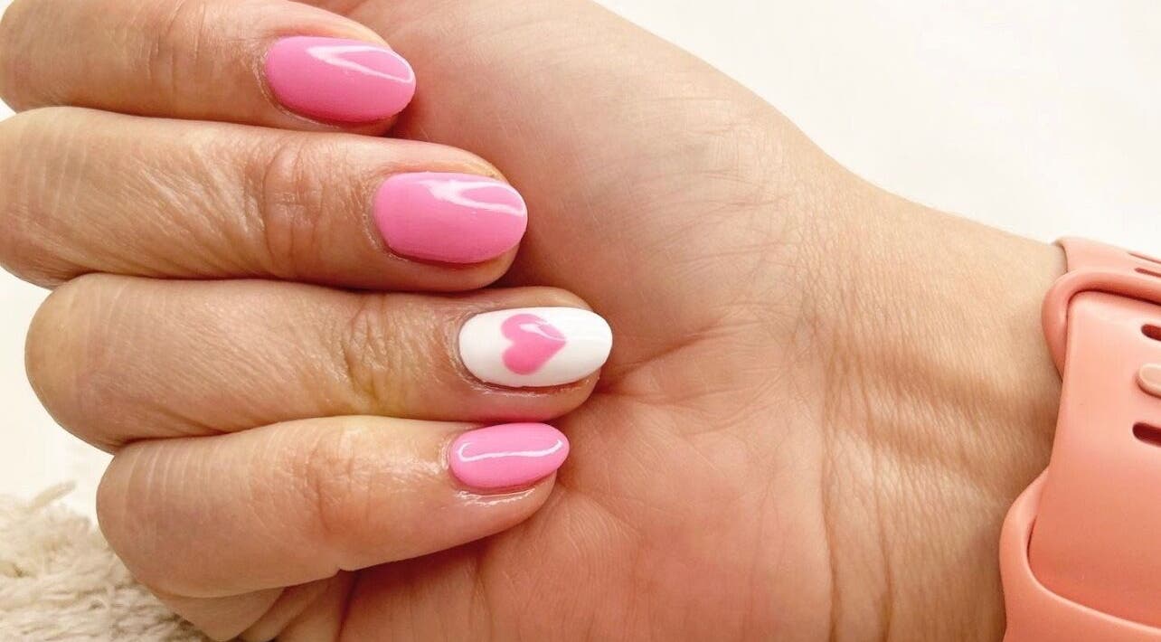 Pink nail design with heart accent at Cove Beauty Co, Poole, England, GB.